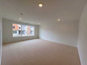 Carpeted spare room with recessed lighting and baseboards