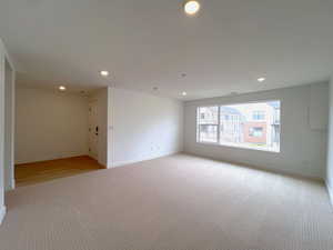 Carpeted empty room with baseboards and recessed lighting