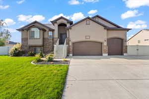 View of front of house featuring stucco siding, brick siding, concrete driveway, a garage, and a gate