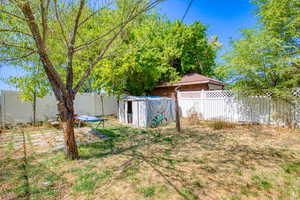 Fenced backyard featuring an outdoor structure