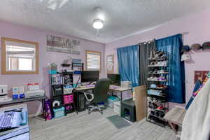 Office space with a textured ceiling and light wood-style floors