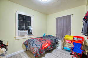 Bedroom with light wood-style floors and a textured ceiling