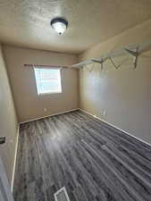 Walk in closet with wood finished floors