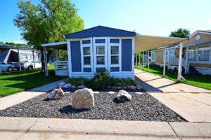 View of front of home featuring driveway, a carport, and a porch