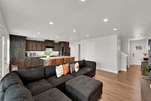 Living area featuring light wood-style flooring and recessed lighting