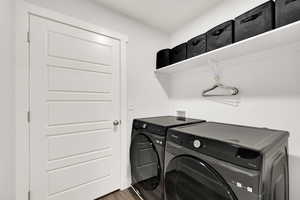 Washroom featuring dark wood finished floors and independent washer and dryer