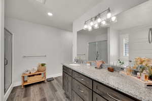 Full bathroom with a stall shower, vanity, dark wood-style flooring, and recessed lighting