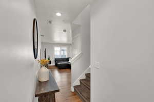 Stairway featuring wood finished floors, a textured ceiling, and recessed lighting