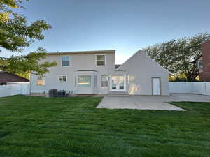 Rear view of property featuring a fenced backyard, a patio area, and french doors