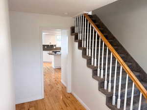 Stairs with hardwood / wood-style floors and baseboards