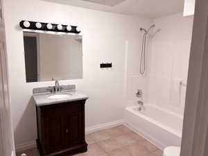 Bathroom with shower / washtub combination, vanity, and light tile patterned floors