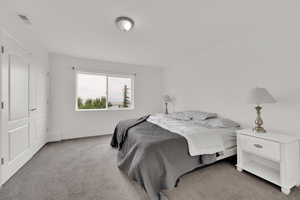 Bedroom with light colored carpet and baseboards