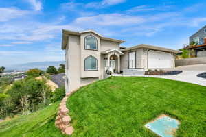 View of front of property with stucco siding, a front yard, concrete driveway, and an attached garage