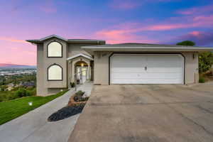 View of front of home with stucco siding, driveway, and a garage