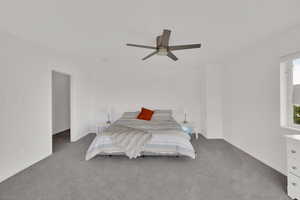 Carpeted bedroom featuring ceiling fan and baseboards