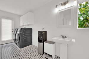 Laundry room featuring independent washer and dryer and cabinet space