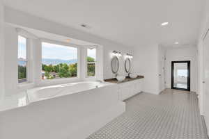 Bathroom with double vanity, a bath, recessed lighting, and a mountain view
