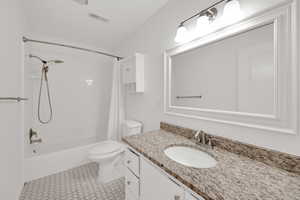 Full bathroom with shower / bath combo with shower curtain, vanity, and light tile patterned flooring