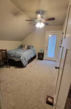 Upstairs bedroom featuring access to outside, ceiling fan, and vaulted ceiling and a walk-in closet