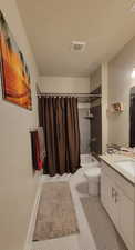Bathroom with shower / tub combo with curtain, vanity, and light tile patterned floors