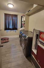 Laundry area featuring a textured ceiling, light wood-style floors, and washing machine and dryer