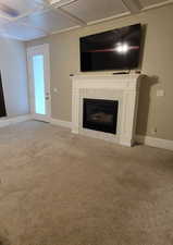 Master Bedroom with coffered ceiling, light carpet, a fireplace, and door to patio.