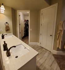 Master bathroom featuring a spacious closet and double vanity