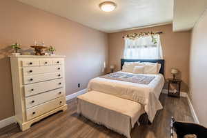 Master bedroom with LVP flooring and window that faces South