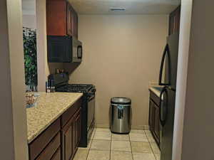 Kitchen with gas range, dishwasher and refrigerator