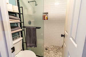 Walk-in shower with sliding glass door and tiled floor and shower