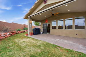 Fenced yard with a ceiling fan and a patio area