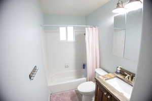 Full bath featuring shower / bath combo with shower curtain and vanity