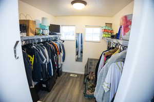 Spacious Master closet with dark wood-style floors