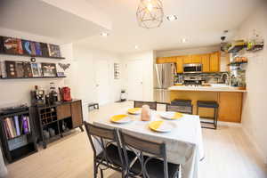 Dining area with recessed lighting and light wood-style floors
