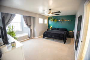 Carpeted bedroom featuring baseboards and a ceiling fan