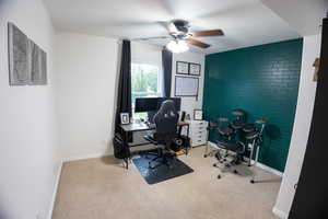 Office area with a ceiling fan, carpet, and a textured ceiling