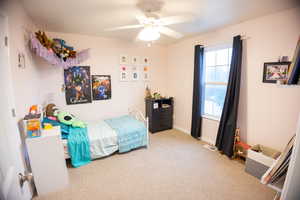 Bedroom with light colored carpet and a ceiling fan