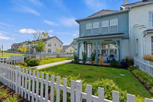 View of front of home with a fenced front yard, a residential view, and a porch