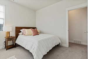 Bedroom featuring light colored carpet and baseboards