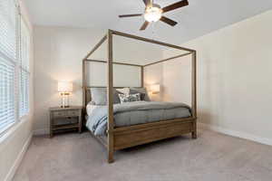 Bedroom with light carpet and a ceiling fan