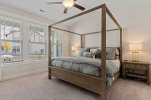Bedroom featuring light colored carpet, vaulted ceiling, and ceiling fan