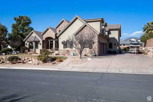 French country style house with stone siding, stucco siding, and driveway