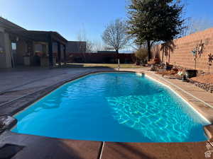 View of pool featuring a fenced backyard, a patio, exterior kitchen, and a pergola