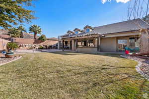 Rear view of house featuring a pergola, stucco siding, and a patio
