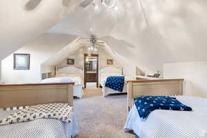 Carpeted bedroom with vaulted ceiling, a textured ceiling, and a ceiling fan