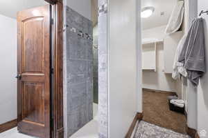 Bathroom with a shower stall, a closet, and a textured ceiling