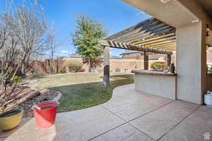 Fenced backyard featuring a pergola, a patio, and an outdoor kitchen