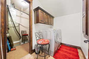 Laundry room with a textured ceiling, independent washer and dryer, and cabinet space