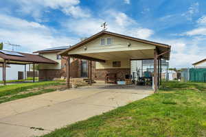 View of front facade with a patio, brick siding, driveway, and entry steps