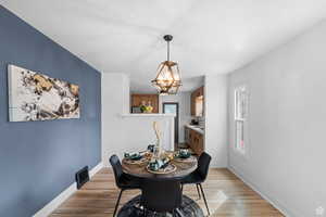 Dining room with light wood-style flooring and a chandelier